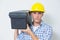 Serious handyman in yellow hard hat carrying toolbox