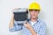 Serious handyman in yellow hard hat carrying toolbox