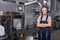 Serious industrial female engineer in spectacles standing in factory at work place