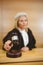 Serious judge with a gavel wearing robes and wig