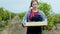 Serious lady countryside walking in front of the camera full of the grapes wooden basket through the vineyard she