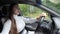 Serious lady in long white dress drives new car closeup