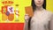 Serious lady showing passport, isolated on Spanish flag background, election