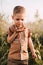 A serious little boy holds a snail in his hand in nature