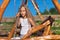 Serious little girl on wooden chain swing