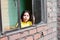 Serious little latin girl standing near window.