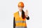 Serious-looking disappointed asian female architect, construction manager at working area wearing safety helmet, showing