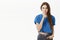 Serious-looking intense displeased young bossy woman with long brown hair in trendy blue cropped t-shirt shushing at