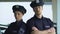 Serious-looking police officers in hats posing on camera, district security