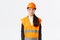 Serious-looking professional female asian construction engineer, architect at building area wearing uniform, safety