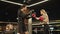 Serious male boxer instructing female boxer on boxing ring. Sport couple at gym