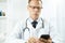 Serious male doctor using mobile phone at work