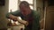 Serious man decorating wooden product indoors. Wood worker using tools in studio