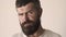 Serious man face close up. Portrait of handsome bearded young guy looking at camera.