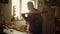 Serious man preparing wooden plank for product indoors. Man blowing out sawdust