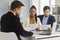 Serious married couple carefully reads paper documents sitting with a bank agent in the office.