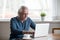 Serious mature man working on computer at home