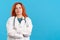 Serious mature redheaded female doctor standing with arms crossed