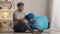 Serious middle aged man putting on boxing gloves sitting on exercise mat. Portrait of focused confident sportsman