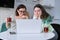 Serious mother and teenage daughter looking at laptop computer