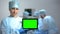 Serious nurse holding tablet PC with green screen during operation, death rate