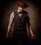 Serious old-fashioned man with hat posing on dark background.