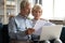 Serious older couple managing budget together, reading documents