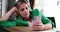 Serious pensive beautiful woman sitting at table in workplace and holding gadget looks at smartphone screen