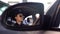 Serious police woman in sunglasses driving car, view from car mirror, order