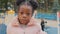 Serious portrait cute little afro American kid no emotion close-up alone small girl looking at camera urban playground