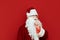 Serious Santa showing a gesture of silence on a red background, looking into the camera with a serious face. Tsh. Santa asks for