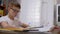 Serious Schoolboy with Glasses Writes with Pen in Notebook, Does Lessons. 4K