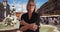 Serious senior lady with arms crossed looking sternly near fountain in Rome