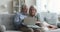 Serious senior old married couple using laptop together on couch