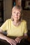 Serious senior woman seated at table