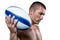 Serious shirtless rugby player holding ball