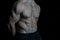 Serious about staying in shape. Torso with six packs looks attractive on black background. Muscular torso huge muscles