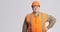 Serious stout construction worker in helmet on grey background, foreman in managing pose