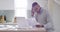 Serious, stressed and depressed man reading paperwork and typing on a laptop while struggling with financial problems