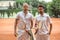 serious tennis players with wooden rackets and ball posing after game