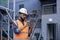 Serious thinking and focused engineer working in factory in hard hat and vest, man using tablet computer reading diagram