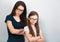 Serious thinking mother and sad doubt kid in glasses with folded arms on light blue background. Closeup studio portrait. Online