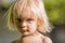 Serious thinking or sad young baby caucasian blonde real people girl close portrait outdoor