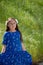 Serious and Thoughtful Little Girl in Blue Dress in front of golden field at Park