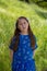 Serious and Thoughtful Little Girl in Blue Dress in front of golden field at Park