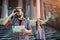 Serious and thoughtful man stand outside and look in binoculars. Also he holds map in hand. Female traveller stand