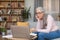 Serious tired busy caucasian senior gray-haired woman teacher in glasses work at laptop in living room interior