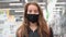 Serious tired woman in protecting mask in shop. A girl standing in grocery store. Pandemic N1H1 coronavirus, virus protection