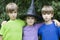 Serious twins and girl in carnival hat