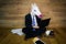 Serious unicorn in a suit and tie works at home office with gadgets